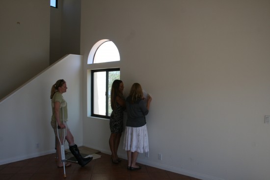 Living room from the fireplace, stairs going up to our bedroom.  We're going to paint that big wall a light greenish accent color.  Window ideas?  I'm thinking we just won't cover the round one?